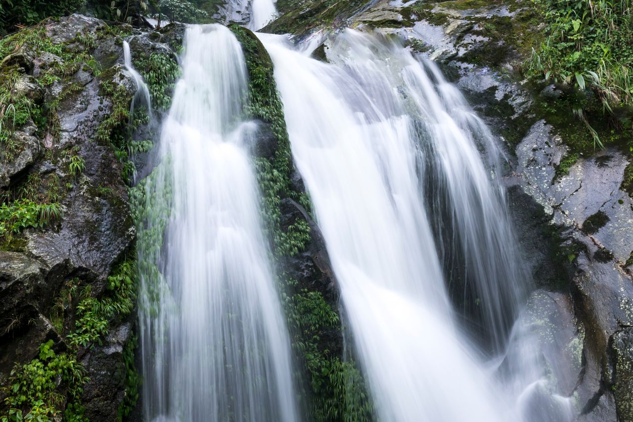 A lush multi-tier rainforest waterfall cascading over mossy rocks in Langkawi