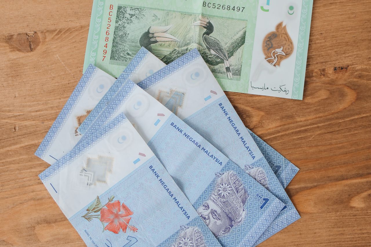 Malaysian ringgit banknotes fanned out on a wooden table